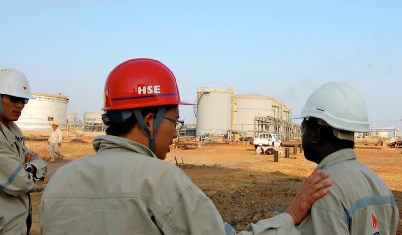 A Chinese worker talks to his colleague at an oil production facility in Sudan in December 2010: China's foray into Africa coincided with the peak of the commodity supercycle.