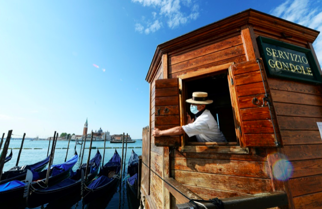 AFP / ANDREA PATTAROA masked gondolier hopes domestic and foreign tourists will take a punt on Italy this summer with the country facing its deepest recession since World War II